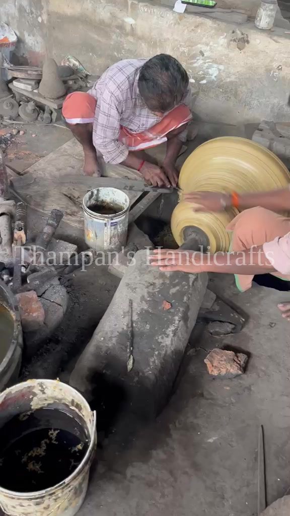 Artisans shaping the wax model of a church bell over its clay core at the Mannar foundry