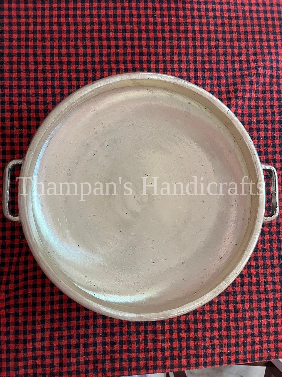 A wide, flat-based bronze pan made to order for cooking payasam